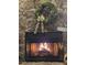 Inviting stone fireplace with a festive wreath and a cozy, warm fire burning inside at 23485 Bluestem Dr, Golden, CO 80401