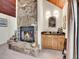 Cozy stone fireplace with a wooden mantle and hearth, complemented by a charming wet bar at 23485 Bluestem Dr, Golden, CO 80401