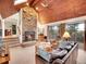 Inviting living room with stone fireplace, wood ceilings, and a door to the outdoor deck at 23485 Bluestem Dr, Golden, CO 80401