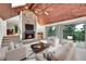 Inviting living room with stone fireplace, wood ceiling, ceiling fan and sliding glass doors to outside deck at 23485 Bluestem Dr, Golden, CO 80401