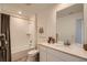 Well-lit bathroom featuring a tub with tiled walls and vanity with countertop space at 495 Bennett Ave, Bennett, CO 80102