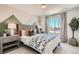 Cozy bedroom with mountain accent wall, stylish furnishings, and a bright window view at 495 Bennett Ave, Bennett, CO 80102