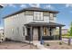 Charming two-story home with gray siding, covered porch, and manicured landscaping at 495 Bennett Ave, Bennett, CO 80102