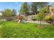 Lush backyard with a playset, mature trees, and well-maintained lawn for outdoor enjoyment at 1762 Granger Cir, Castle Rock, CO 80109
