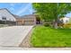 Charming brick home featuring an expansive driveway and a well-manicured lawn with mature landscaping at 1762 Granger Cir, Castle Rock, CO 80109