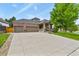 Beautiful home featuring a three-car garage, brick accents, and large driveway with meticulous landscaping at 1762 Granger Cir, Castle Rock, CO 80109
