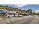 A charming street with local shops and parked cars under a mountain backdrop at 3179 S Russell St, Morrison, CO 80465