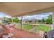 Covered back deck with outdoor seating, offering a relaxing space to enjoy the view of the landscaped backyard at 4864 Harness Ct, Parker, CO 80134