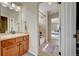 Attached bathroom with wooden cabinets, and view to the shower-tub combo, with natural light at 4864 Harness Ct, Parker, CO 80134