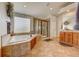 Large primary bathroom with tile floors, bathtub, shower, and cabinets at 4864 Harness Ct, Parker, CO 80134