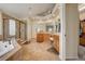 A large primary bathroom with tile floors, dual vanities, bathtub, and glass enclosed shower at 4864 Harness Ct, Parker, CO 80134