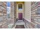 Home entrance with a high stone archway, a red door and large windows at 4864 Harness Ct, Parker, CO 80134
