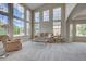 Spacious living room featuring high ceilings, tall windows, and neutral carpet at 4864 Harness Ct, Parker, CO 80134