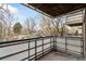 Balcony with metal railing overlooking mature trees and parking at 2500 S York St # 204, Denver, CO 80210