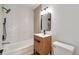 Modern bathroom featuring geometric white tile in shower/tub, wood vanity, and matte black fixtures at 2500 S York St # 204, Denver, CO 80210