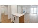 Open-concept living space with a fireplace, wood-look floors, and access to a balcony at 2500 S York St # 204, Denver, CO 80210
