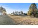 View of back yard surrounded by houses in the distance, a white fence and tall trees at 34427 Columbine W Trl, Elizabeth, CO 80107