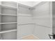 Neutral walk-in closet with built-in shelves and metal hanging racks at 34427 Columbine W Trl, Elizabeth, CO 80107