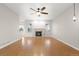 Open-concept living room featuring laminate flooring, a ceiling fan, and a fireplace at 34427 Columbine W Trl, Elizabeth, CO 80107