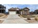 Charming home featuring a two-car garage, a stone-accented facade, and professionally landscaped front yard at 18241 W 93Rd Pl, Arvada, CO 80007