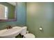 Powder room featuring a white vanity, toilet, mirror, and green painted walls at 5683 Raleigh Cir, Castle Rock, CO 80104
