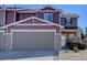 Charming two-story townhome featuring a two-car garage, stone accents, and front entrance at 5683 Raleigh Cir, Castle Rock, CO 80104