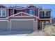 Inviting two-story townhome featuring a two-car garage, stone accents, and fresh landscaping at 5683 Raleigh Cir, Castle Rock, CO 80104