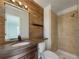 Stylish bathroom featuring wood paneling, updated vanity, and a tiled shower at 927 E 7Th Ave, Broomfield, CO 80020