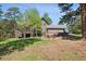 Landscaped backyard with a large deck, stone patio, hot tub, mature trees and lush green grass at 1570 Blakcomb Ct, Evergreen, CO 80439