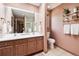Bathroom offers double sink vanity and large mirror with shelf and cabinet for storage at 1570 Blakcomb Ct, Evergreen, CO 80439