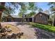 Exterior elevation showcasing beautiful landscaping, stone accents, driveway, and attached three-car garage at 1570 Blakcomb Ct, Evergreen, CO 80439