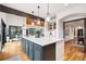 Modern kitchen boasts a large island, pendant lighting, hardwood floors, and seamless flow to the dining area at 1570 Blakcomb Ct, Evergreen, CO 80439