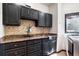 Laundry room offers granite countertops, dark wood cabinets and stainless steel sink at 1570 Blakcomb Ct, Evergreen, CO 80439