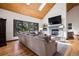 Sunlit living room features a stone fireplace, vaulted ceilings, wood accents, and large windows with backyard views at 1570 Blakcomb Ct, Evergreen, CO 80439
