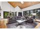Vaulted living room features wood ceilings, many windows, and an oversized gray couch at 1570 Blakcomb Ct, Evergreen, CO 80439
