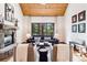 Cozy living room featuring a stone fireplace, wood ceiling and large window views at 1570 Blakcomb Ct, Evergreen, CO 80439