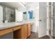 Bright bathroom features a double vanity, bright mirrors, and a shower with decorative tile at 9522 Silver Spur Ln, Highlands Ranch, CO 80130