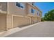 Exterior shot of a townhouse featuring garages with light-brown doors at 9522 Silver Spur Ln, Highlands Ranch, CO 80130