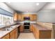 Well-lit kitchen with stainless steel appliances, wood cabinetry and double sink by the window at 9522 Silver Spur Ln, Highlands Ranch, CO 80130