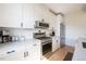 Contemporary kitchen features white cabinetry, stainless appliances, and stone countertops at 2197 S Clermont St, Denver, CO 80222