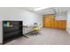Clean basement featuring a desk, storage cabinets, vinyl flooring, and overhead lighting at 1650 Monaco St Pkwy, Denver, CO 80220