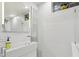 Modern bathroom featuring a sleek sink and glass-block window, all in bright white tile at 1650 Monaco St Pkwy, Denver, CO 80220
