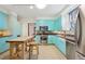 Retro kitchen with teal cabinets, stainless steel appliances, and wooden island at 1650 Monaco St Pkwy, Denver, CO 80220