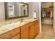 Bathroom with granite countertop, wood cabinets and access to walk-in closet at 6468 S Hudson St, Centennial, CO 80121