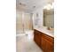 Bathroom with a shower featuring a frosted glass door, wood cabinet, and white fixtures at 6468 S Hudson St, Centennial, CO 80121