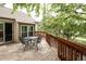 Exterior view of a wood deck overlooking a wooded area with black patio furniture at 6468 S Hudson St, Centennial, CO 80121