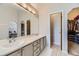 Bathroom vanity with double sinks, white cabinetry, and a view into the main bedroom at 21562 Omaha Ave, Parker, CO 80138