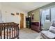 Well-lit Bedroom with a wooden crib, plush gray chair and decorative woodland themed decor at 21562 Omaha Ave, Parker, CO 80138