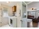 Bright laundry room with modern washer and dryer, convenient storage cabinets, and a view into a cozy living space at 21562 Omaha Ave, Parker, CO 80138