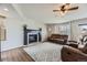 Comfortable living room featuring a ceiling fan, fireplace and large grey diamond pattern rug at 21562 Omaha Ave, Parker, CO 80138